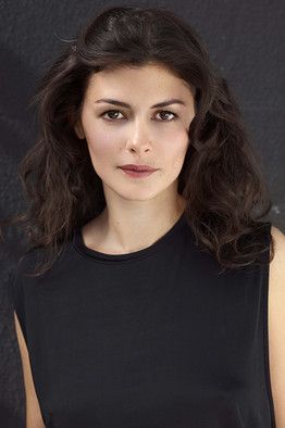 a woman in a black dress posing for a photo