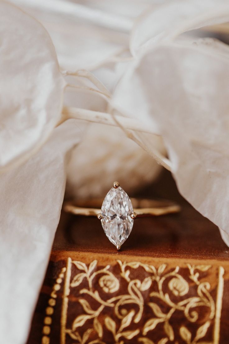 an engagement ring sitting on top of a book