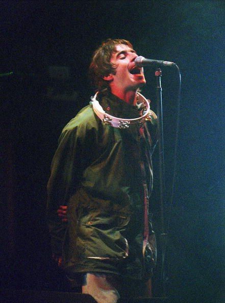 a man standing in front of a microphone on top of a stage with his mouth open