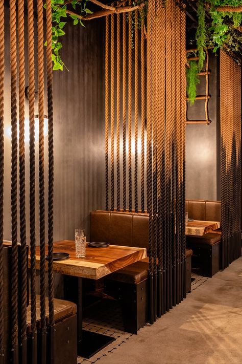 the interior of a restaurant with wooden tables and benches, hanging plants on the wall