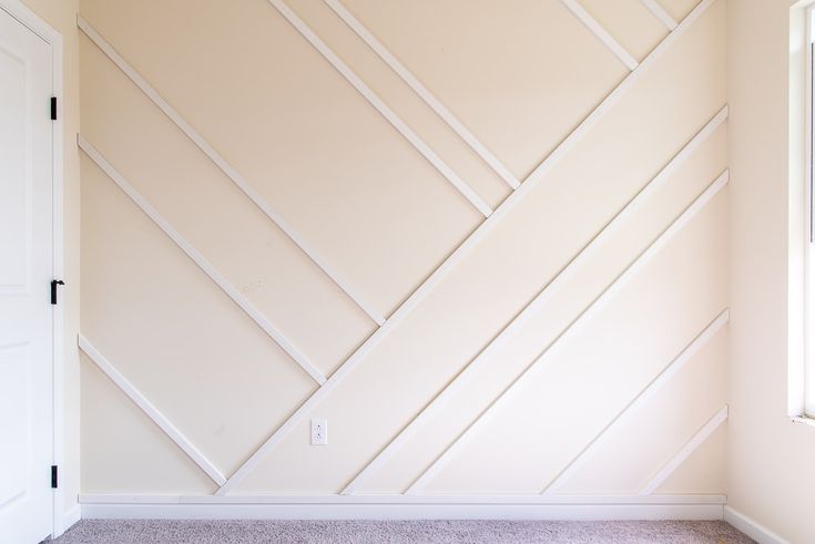 an empty room with white paint and wood paneling