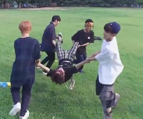 a group of young men are playing tug - ball in the park