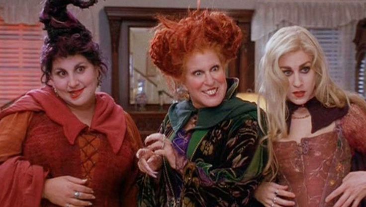 three women dressed in costumes standing next to each other, one with red hair and the other with green eyes