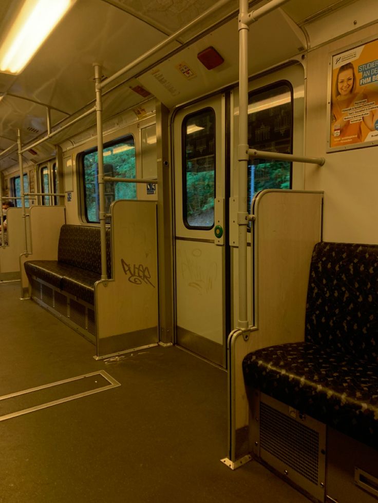 the inside of a subway car with seats and railings