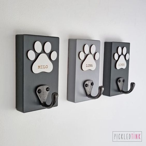 three metal wall hooks with paw prints on them