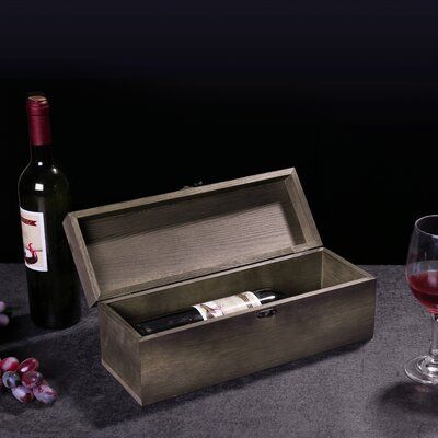 a bottle of wine sitting next to a wooden box with a corkscrew in it