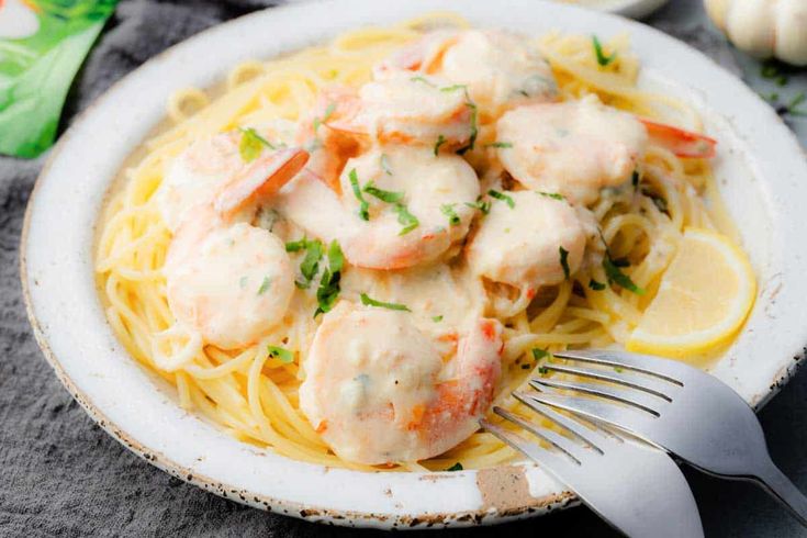 a white plate topped with shrimp and pasta