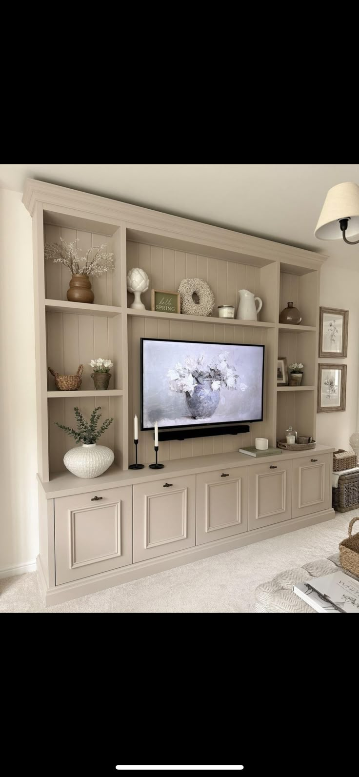 a living room with a large tv on the wall