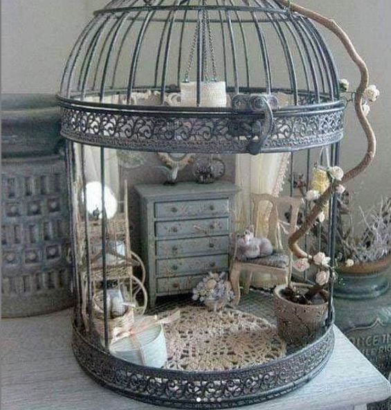 a birdcage filled with lots of stuff sitting on top of a table