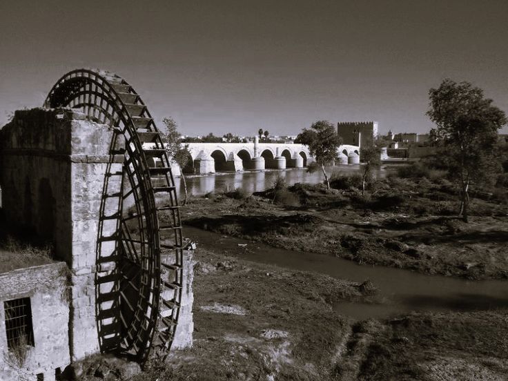 a black and white photo of a water wheel