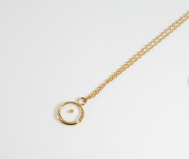 a gold necklace with a circle on it