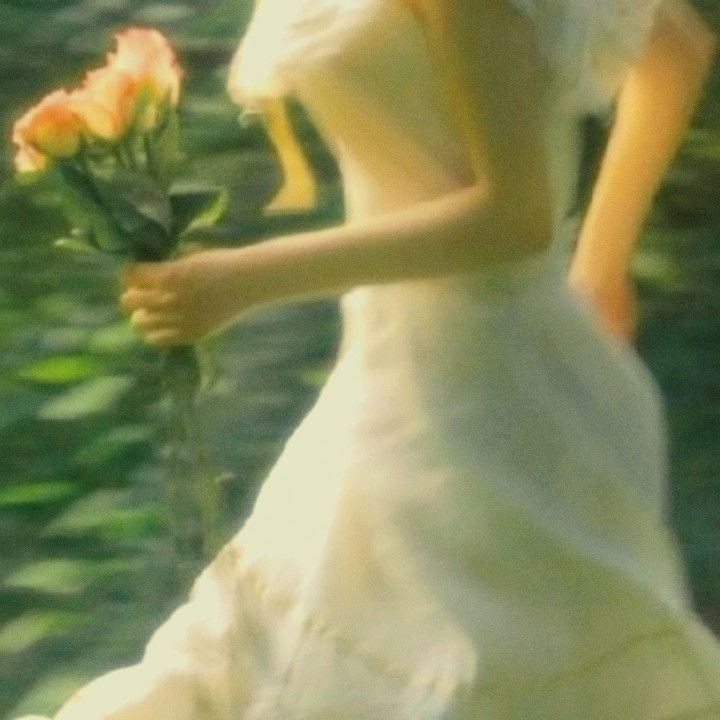 a woman in a white dress holding a rose