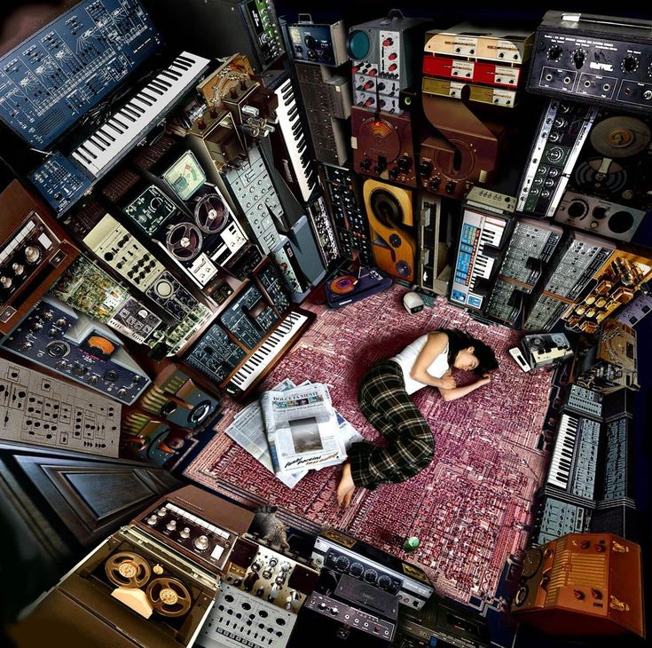 a person laying on top of a rug surrounded by musical instruments and other electronic equipment