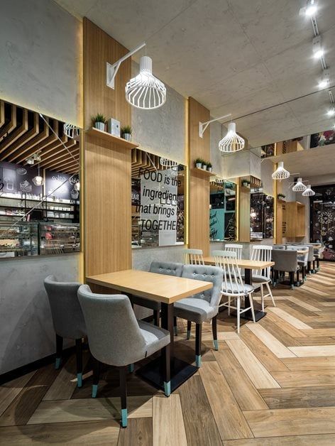 an empty restaurant with wooden floors and white chairs