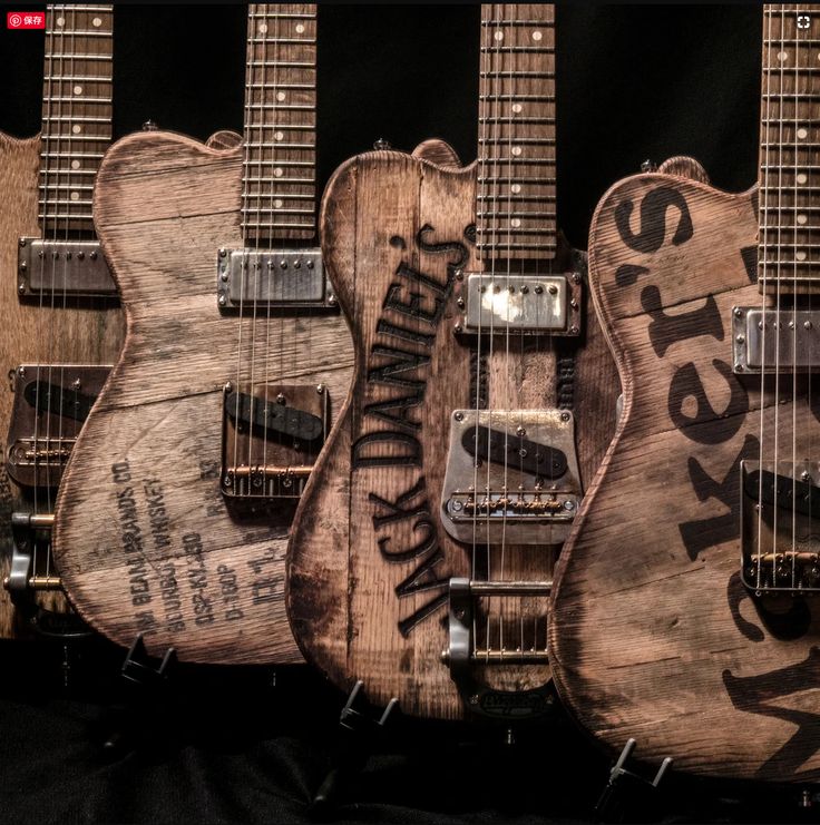 three guitars are lined up on display in front of a black background with the words rock'n'roll written on them