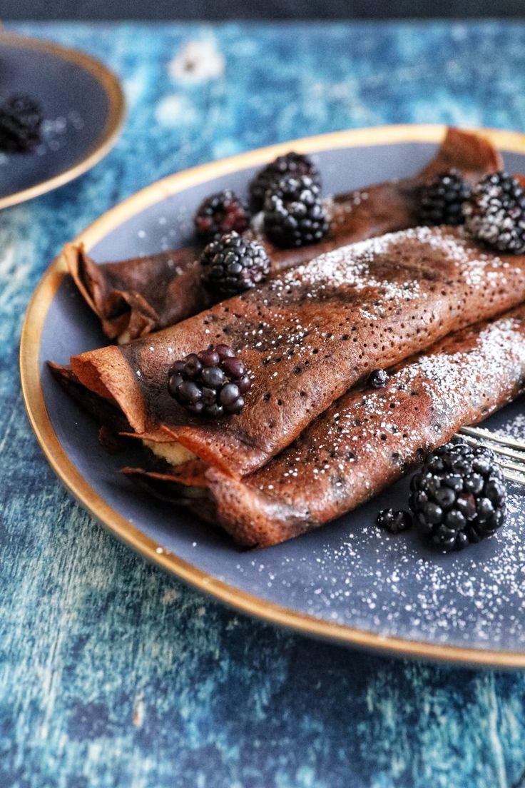 pancakes with berries and powdered sugar on a plate