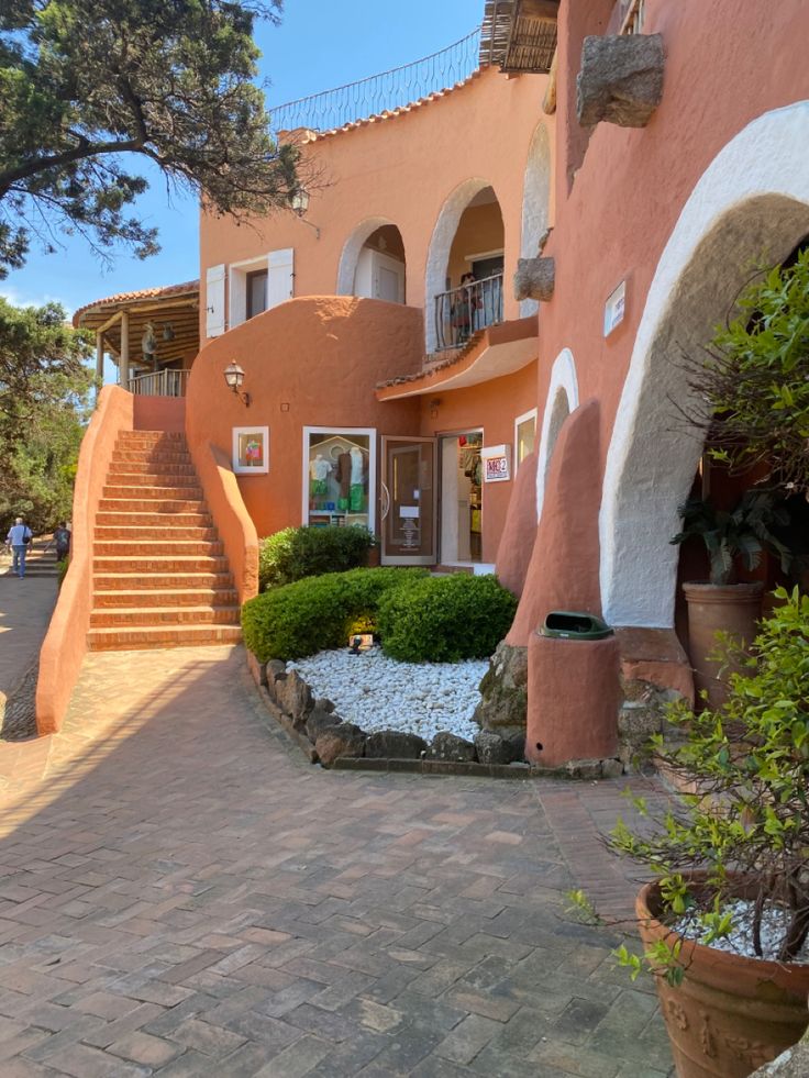 the entrance to an apartment building with steps leading up to it's second floor