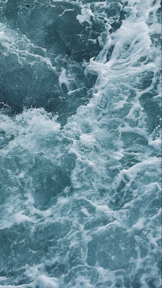 a person riding a surfboard on top of a wave in the ocean with foamy water