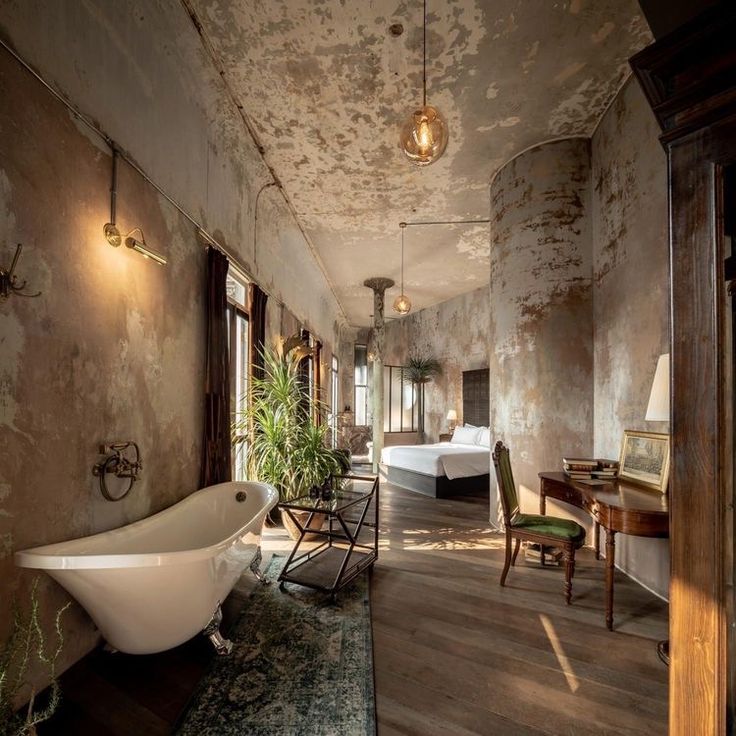 a bath tub sitting in the middle of a room next to a table and chairs