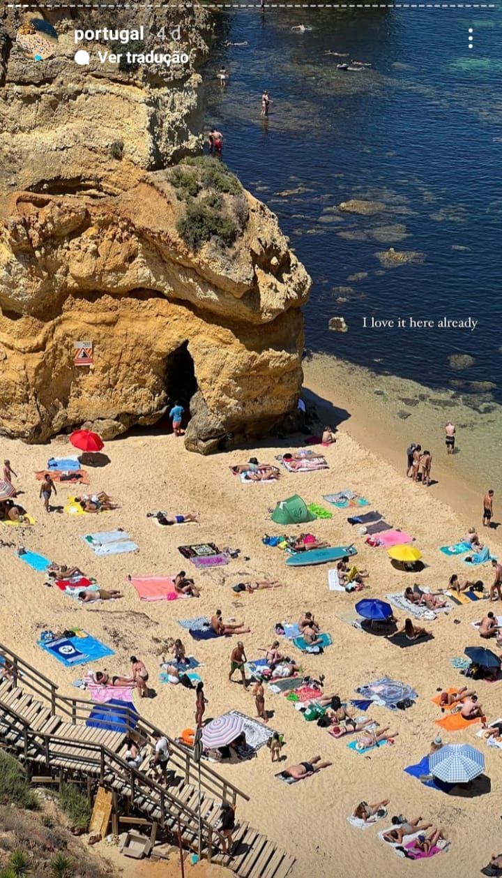 many people are laying on the beach under umbrellas and sunbathers in the water