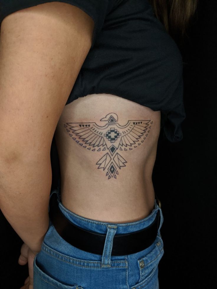 a woman's stomach with a tattoo on her belly and an eagle in the center