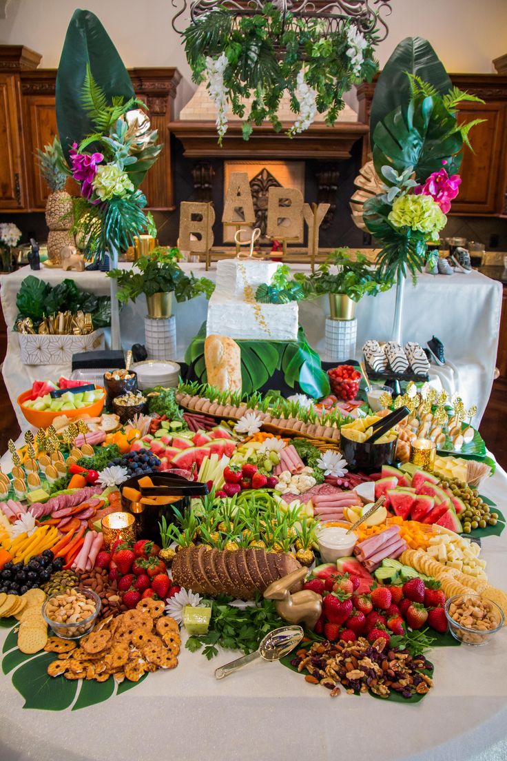 a table filled with lots of different types of food on top of a white table cloth