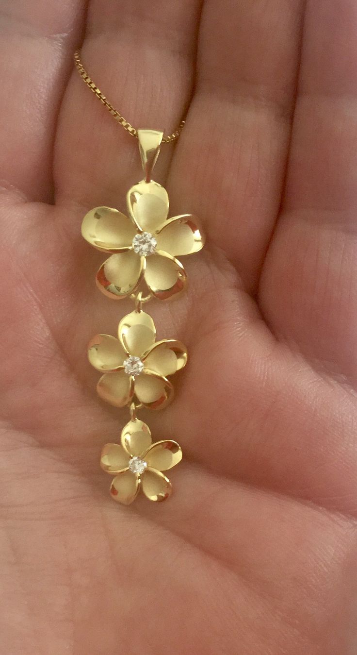 "Solid .925 Sterling Silver with 14K Gold overlay Hawaiian three Plumeria past, present and future necklace. The Drop length is 50MM, about 1.9\". The Plumerias descend from 17MM to 13MM to 10MM. FREE Sterling Silver Box chain included in your choice of length. --The Pendant has a Matte center with eye-catching high-polished edges. It has Cubic zirconias in the Flowers center for a touch of sparkle. It is designed to mimic the look of fine jewelry at a fraction of the cost. --The Plumeria is sac Silver Flower Jewelry, Yellow Gold Hallmarked Flower Jewelry, Hallmarked Yellow Gold Flower Jewelry, Anniversary Yellow Gold Flower Necklace, Gold Necklace Stacks, Gold Summer Jewelry, Lotus Jewelry Gold, Plumeria Jewelry, Gold Jewlry