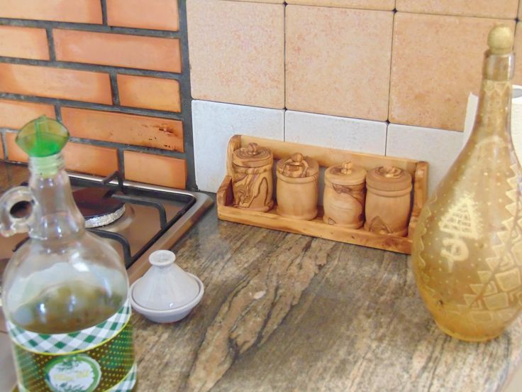 a wooden cutting board sitting on top of a kitchen counter next to a bottle of olive oil