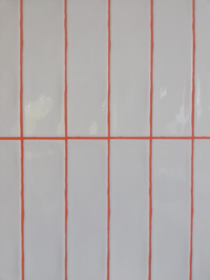 an orange and white tiled wall with lines on it