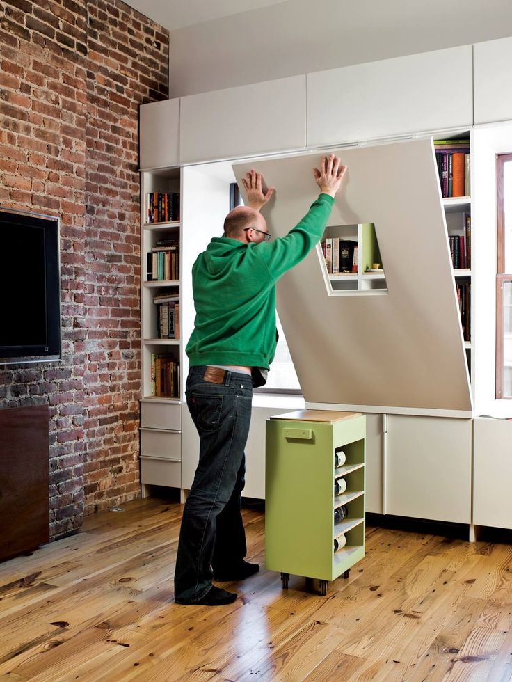 a man standing in front of a white refrigerator freezer next to a wooden floor