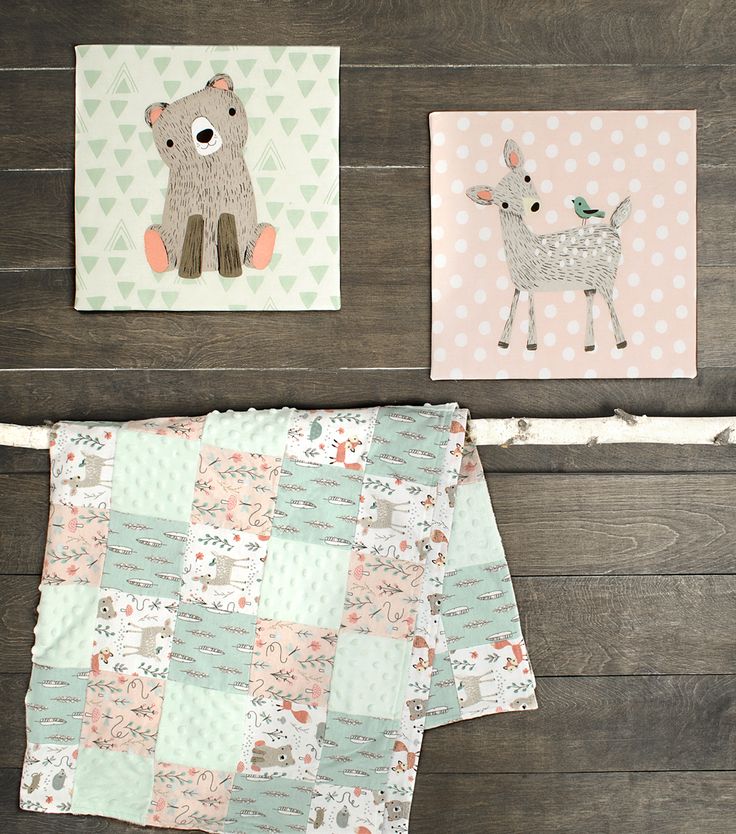 three baby quilts with animals on them sitting on top of a wooden floor next to each other