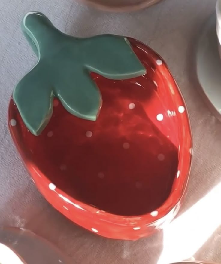 a strawberry shaped bowl sitting on top of a table