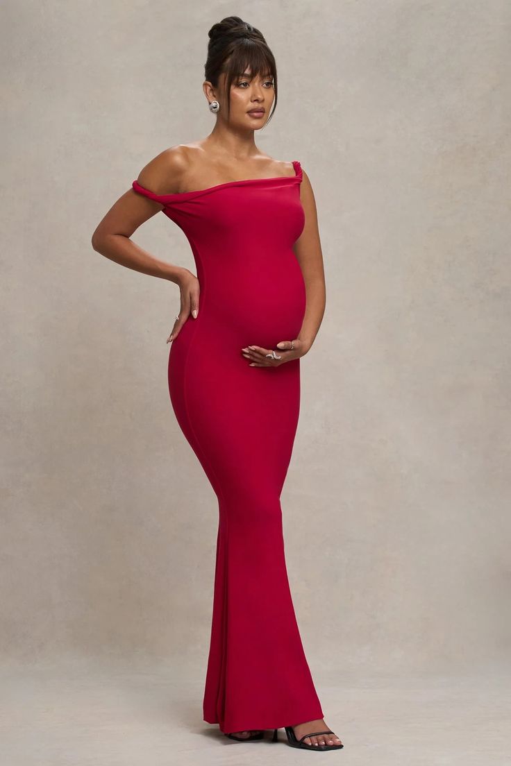 a woman in a red dress posing for the camera with her hands on her hips