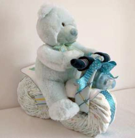 a white teddy bear sitting on top of a scooter with a blue bow