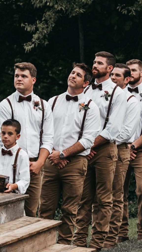 a group of men standing next to each other wearing brown suspenders and bow ties