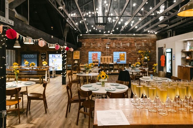 a room filled with lots of tables and chairs covered in wine glasses next to each other