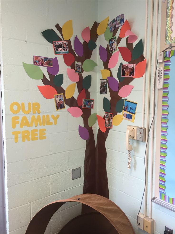 a tree made out of colored paper with pictures on it and the words our family tree