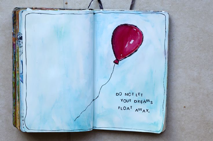 an open book with a drawing of a red balloon flying in the sky on it