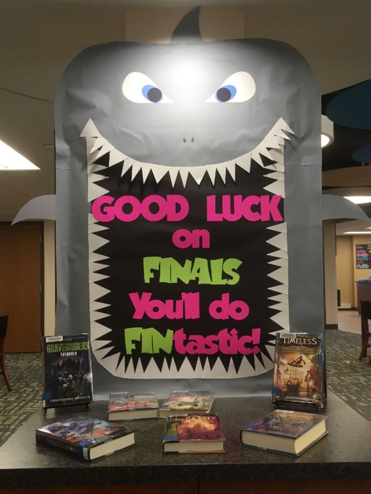 some books are sitting on a table in front of a sign that says, good luck on final you'll do fantastic