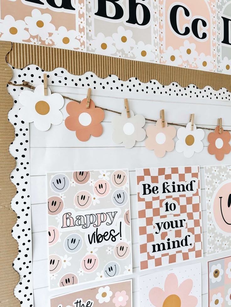 a bulletin board with lots of stickers on it and some paper flowers hanging from the pegs