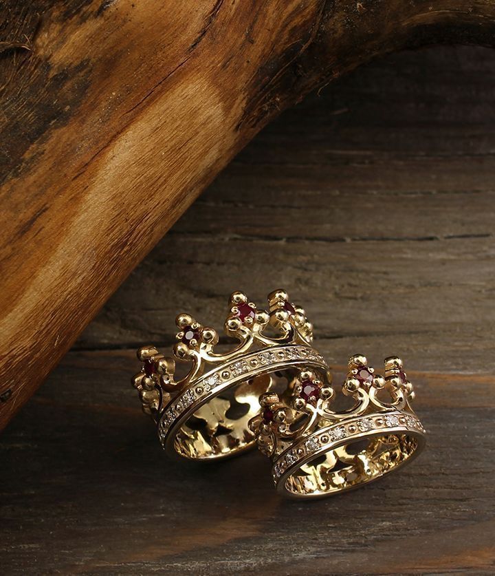 two gold rings sitting on top of a wooden table