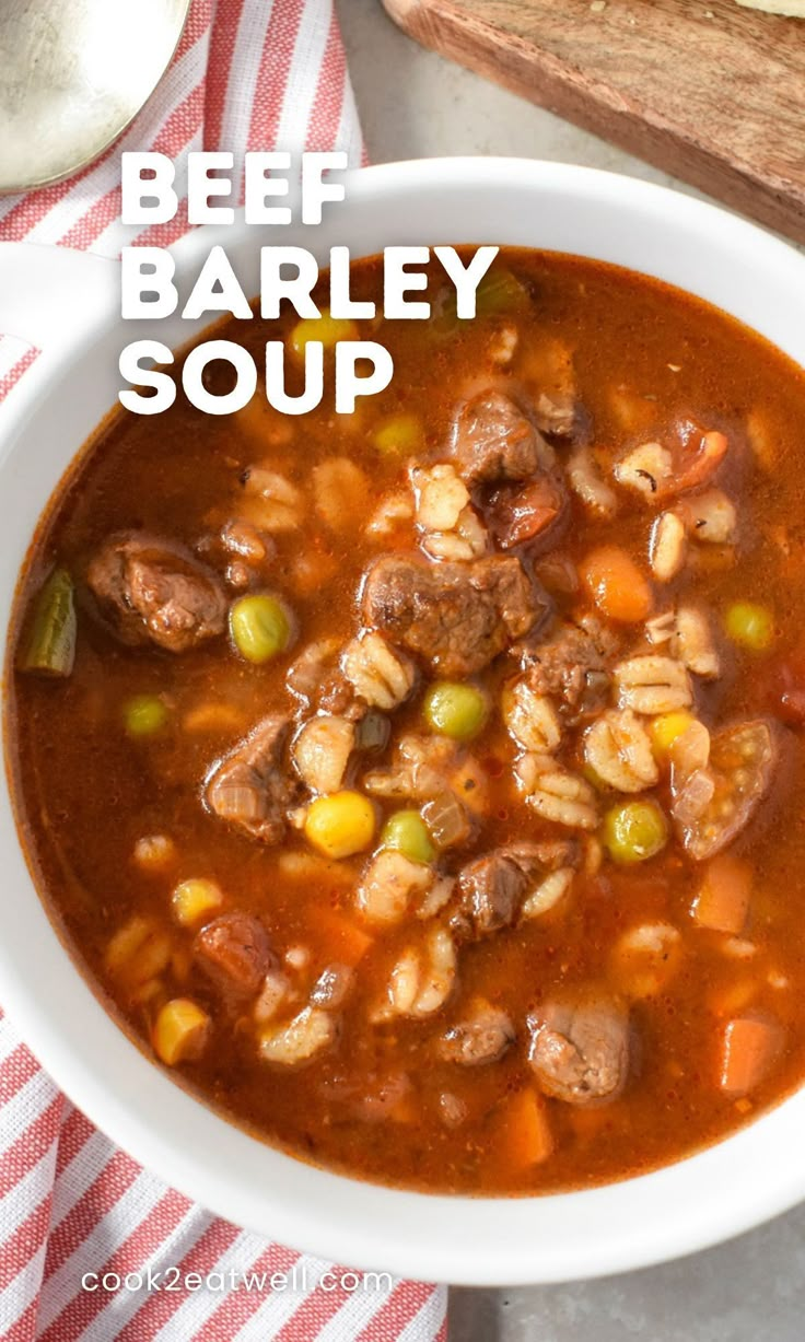 beef barley soup in a white bowl on top of a red and white striped napkin