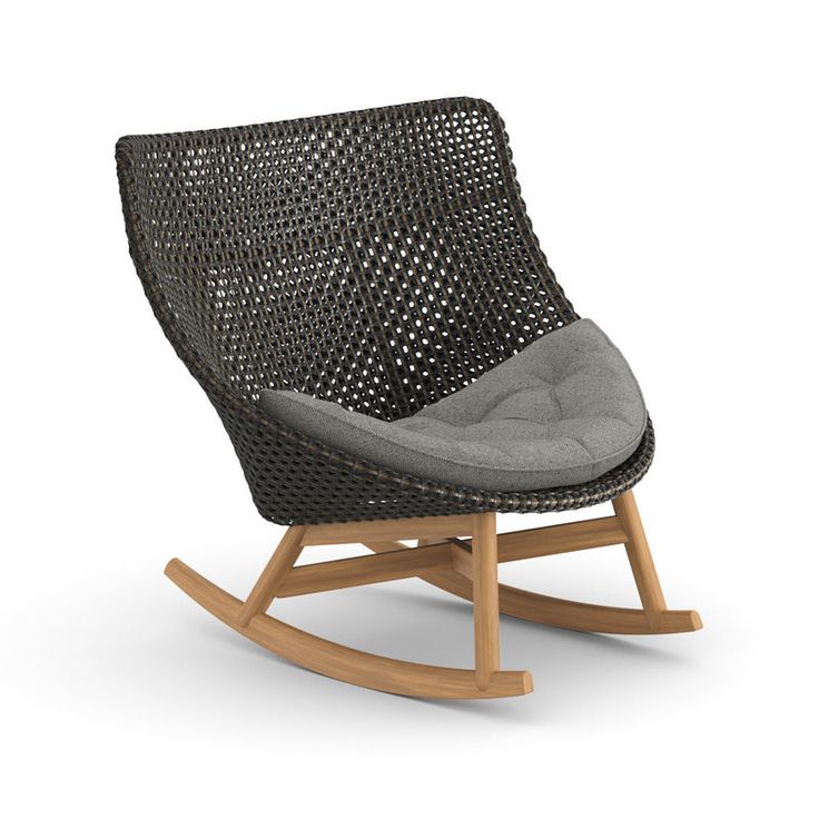 the rocking chair is made out of wicker and has a grey cushion on it