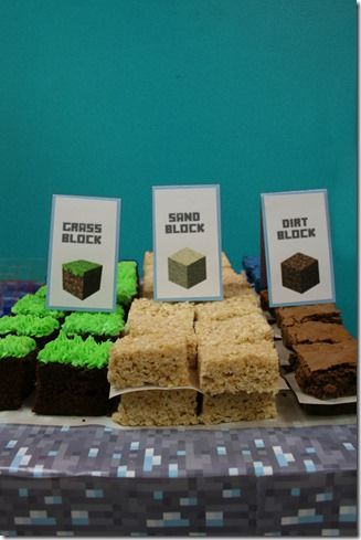 a table topped with cakes and cupcakes on top of a blue table cloth