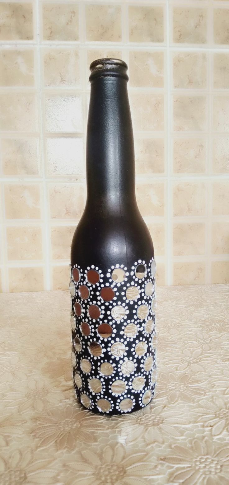 a brown bottle sitting on top of a counter next to a tiled wall behind it