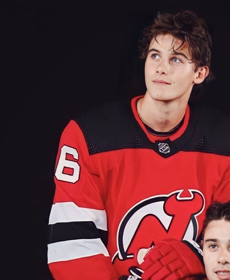 two men in hockey jerseys posing for a photo