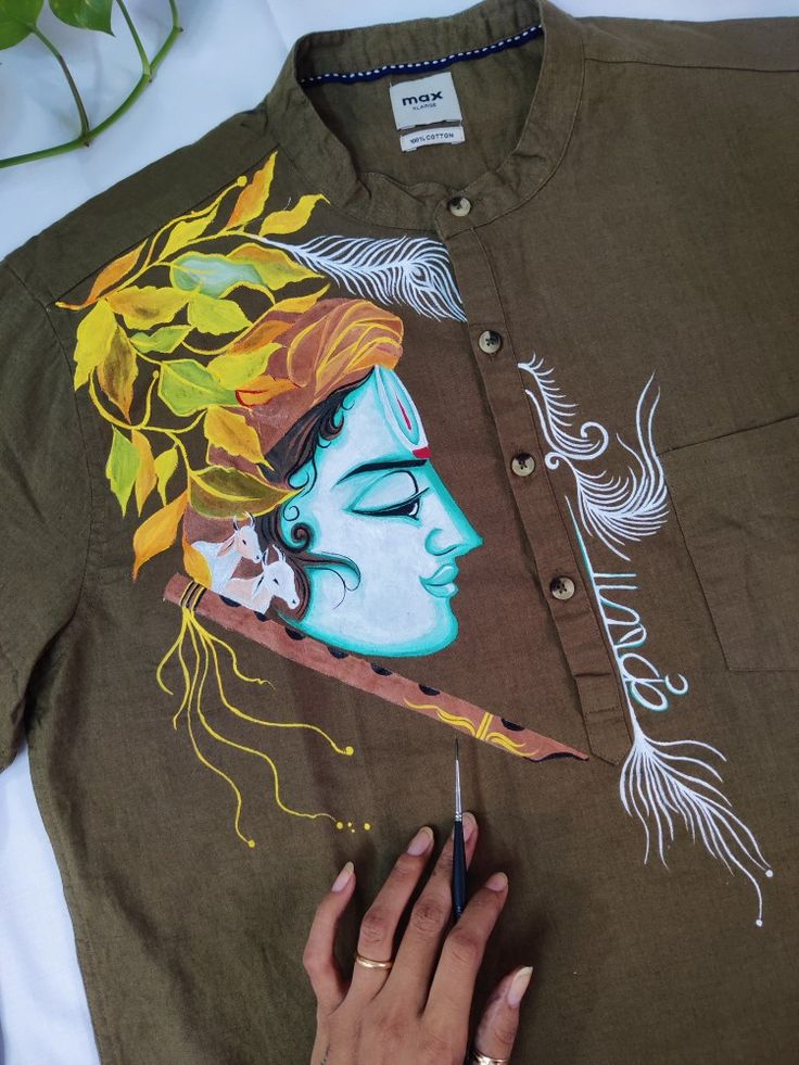 a person is drawing on a shirt that has an image of a woman's face