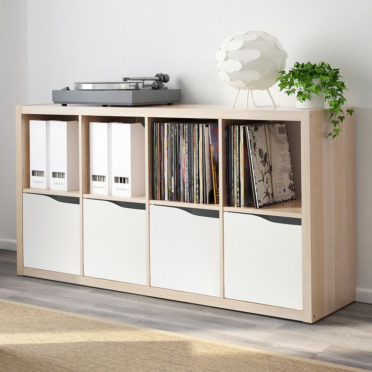 an entertainment center with drawers and records on the top, next to a record player