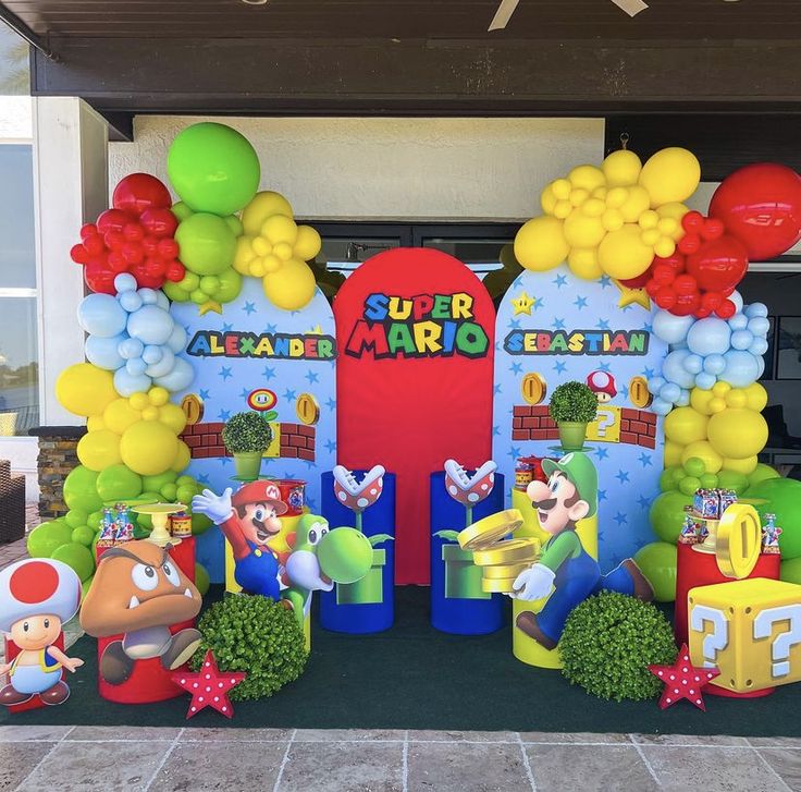 an entrance to a super mario birthday party with balloons and decorations on the front door