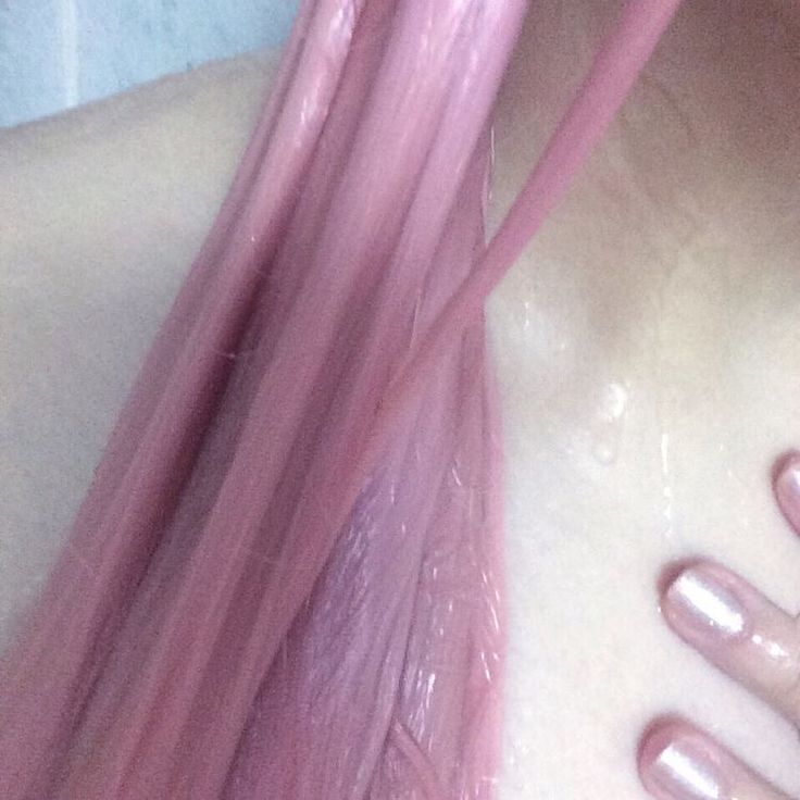 a woman with long pink hair and nails on her chest is shown from the top down